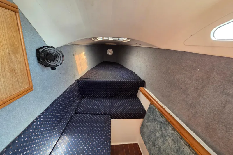 Prosecco Yacht Photos Pics Interior cabin of a 1997 Seawind 1000 catamaran with blue upholstery and wooden accents.