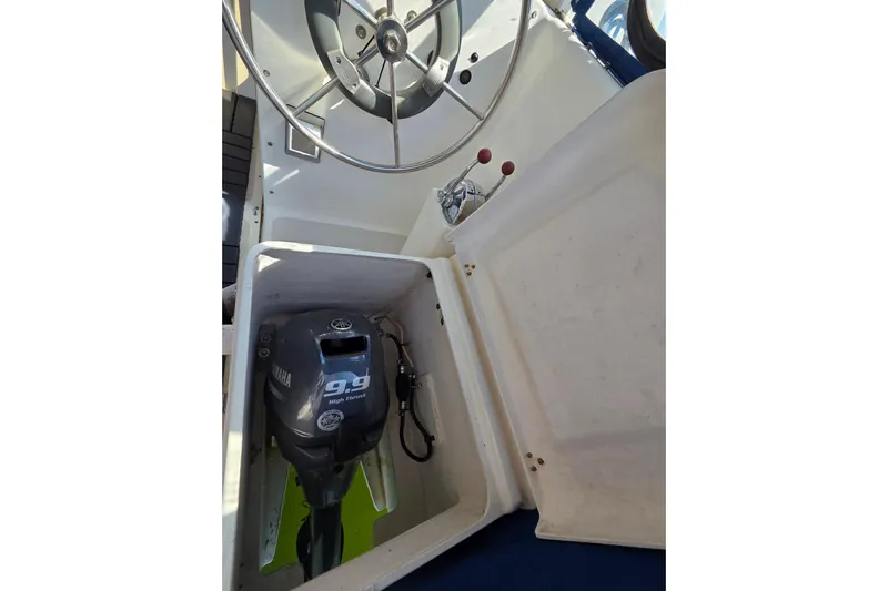 Prosecco Yacht Photos Pics 1997 Seawind 1000 boat helm with Yamaha 9.9 high thrust outboard motor.