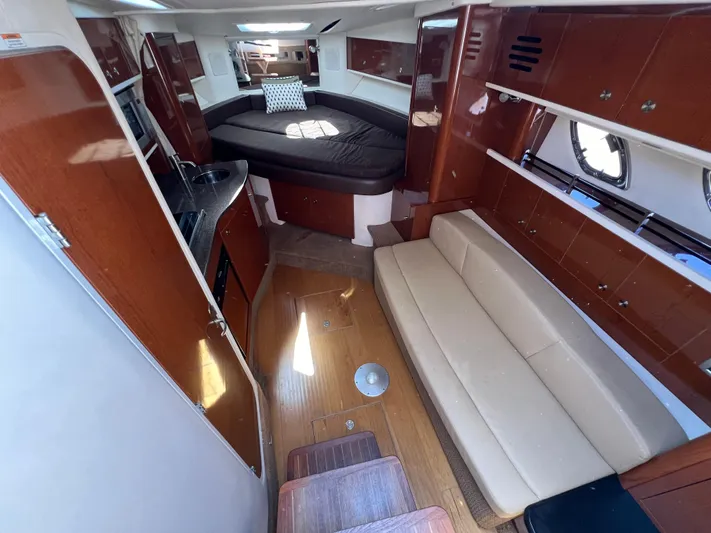 Freedom Of The Seize Yacht Photos Pics Interior of 2014 Sea Ray 330 Sundancer with bed, sofa, and kitchenette.