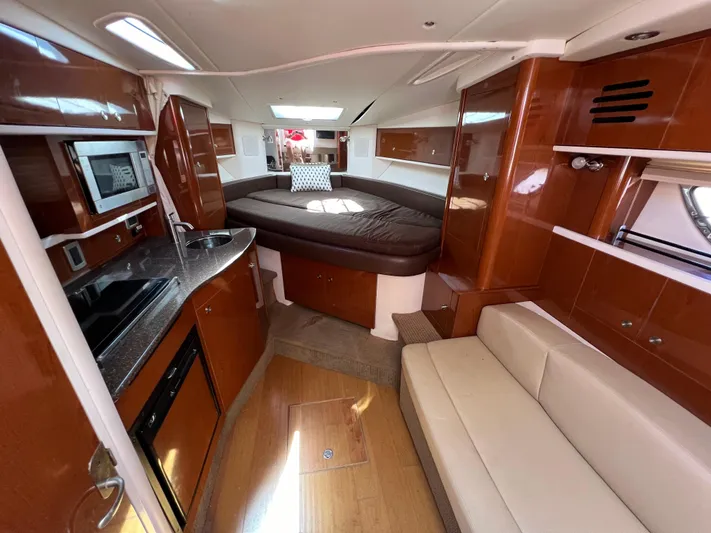 Freedom Of The Seize Yacht Photos Pics Interior of 2014 Sea Ray 330 Sundancer with kitchen, seating, and bed.
