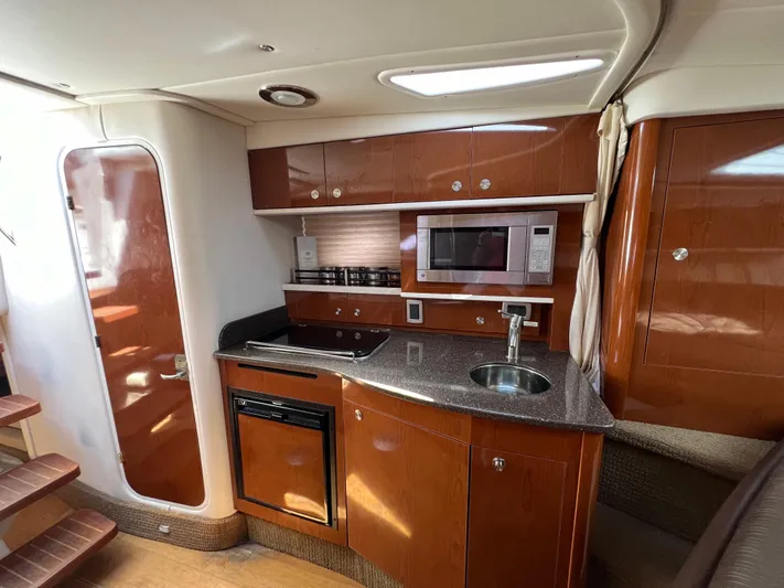Freedom Of The Seize Yacht Photos Pics 2014 Sea Ray 330 Sundancer kitchen with microwave, sink, and stove.