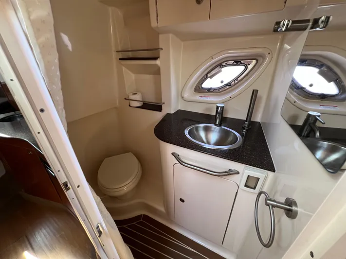 Freedom Of The Seize Yacht Photos Pics 2014 Sea Ray 330 Sundancer bathroom with sink, toilet, and porthole window.