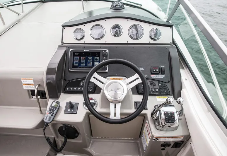 Freedom Of The Seize Yacht Photos Pics 2014 Sea Ray 330 Sundancer helm with steering wheel, gauges, and navigation controls.