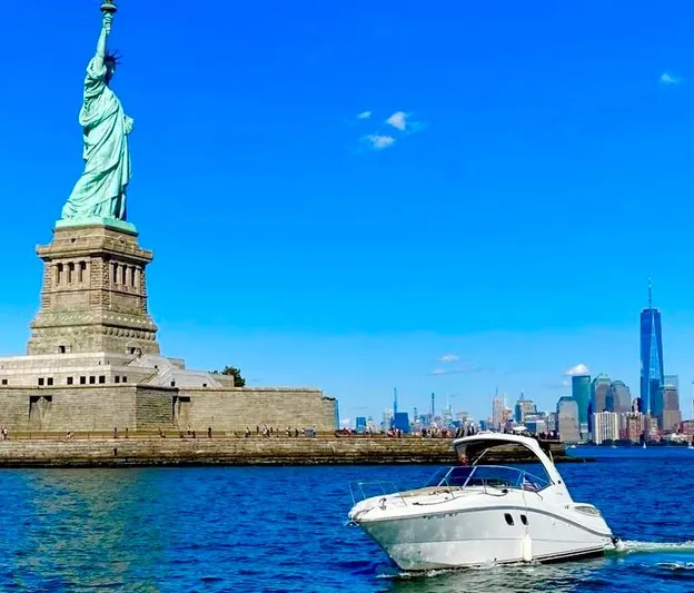 Freedom Of The Seize Yacht Photos Pics Sea Ray 330 Sundancer 2014 near Statue of Liberty, New York City skyline in background.