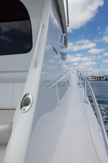 "el Jefe" Yacht Photos Pics 2014 Viking 70 Convertible yacht, sleek white exterior, docked under a partly cloudy sky.