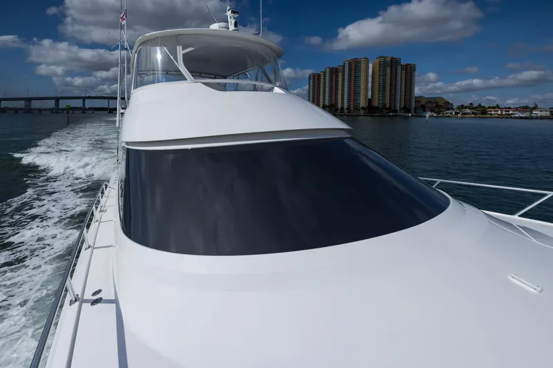 "el Jefe" Yacht Photos Pics 2014 Viking 70 Convertible yacht cruising on water with cityscape in background.