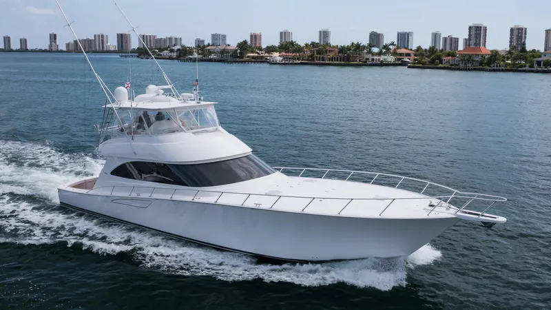 "el Jefe" Yacht Photos Pics 2014 Viking 70 Convertible yacht cruising on a coastal waterway with city skyline backdrop.