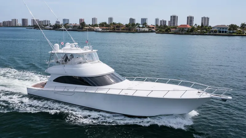 "el Jefe" Yacht Photos Pics 2014 Viking 70 Convertible yacht cruising on a calm waterway near a city skyline.