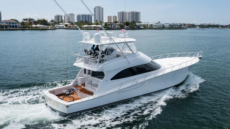 "el Jefe" Yacht Photos Pics 2014 Viking 70 Convertible yacht cruising in a coastal cityscape.