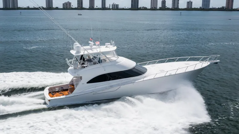 "el Jefe" Yacht Photos Pics 2014 Viking 70 Convertible yacht cruising on open water, city skyline in background.