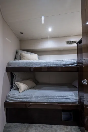"el Jefe" Yacht Photos Pics Bunk beds in 2014 Viking 70 Convertible yacht cabin, featuring cozy bedding and modern lighting.