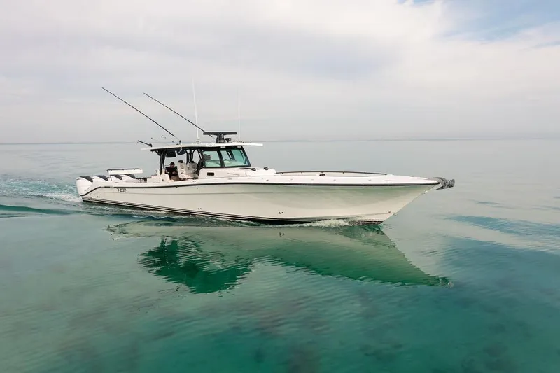  Yacht Photos Pics 2019 HCB 53 boat cruising on calm, clear water under a cloudy sky.