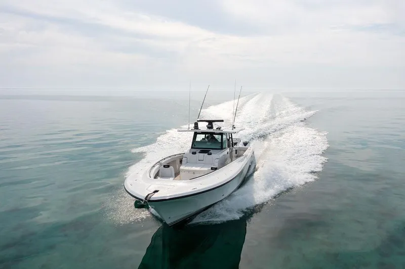  Yacht Photos Pics 2019 HCB 53 boat cruising on calm, clear waters under a cloudy sky.
