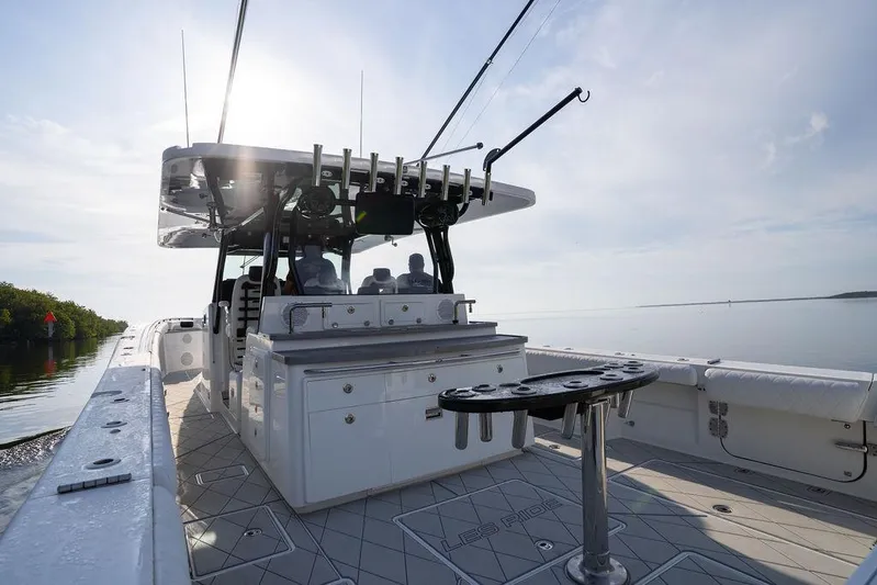  Yacht Photos Pics 2019 HCB 53 boat with fishing setup, cruising on calm waters under a clear sky.