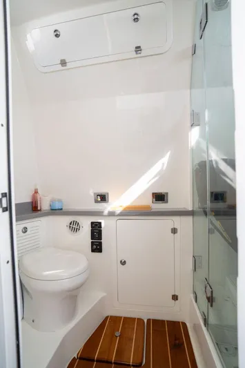  Yacht Photos Pics 2019 HCB 53 boat bathroom with toilet, shower, and wooden flooring.