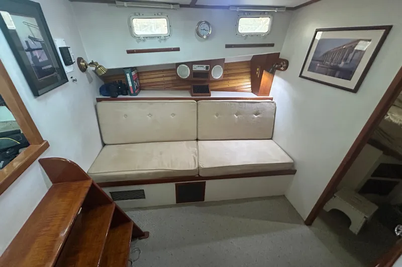  Yacht Photos Pics Cozy interior of 1991 Holland 38 boat with cushioned seating and nautical decor.