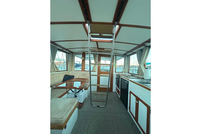  Yacht Photos Pics Interior of 1991 Holland 38 boat with seating, table, and kitchen area.
