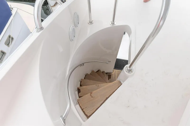  Yacht Photos Pics Spiral staircase on 2004 Bertram 630 yacht with sleek white design.