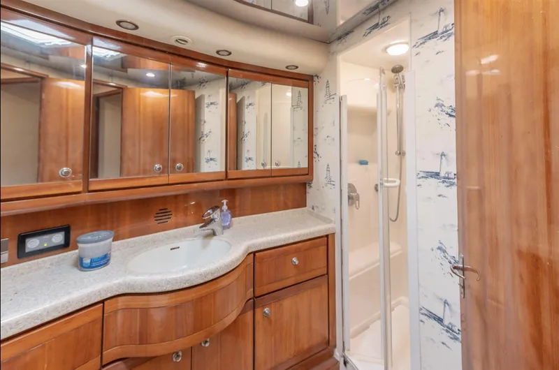  Yacht Photos Pics Luxurious bathroom in 2004 Bertram 630 yacht with wood cabinetry and shower.