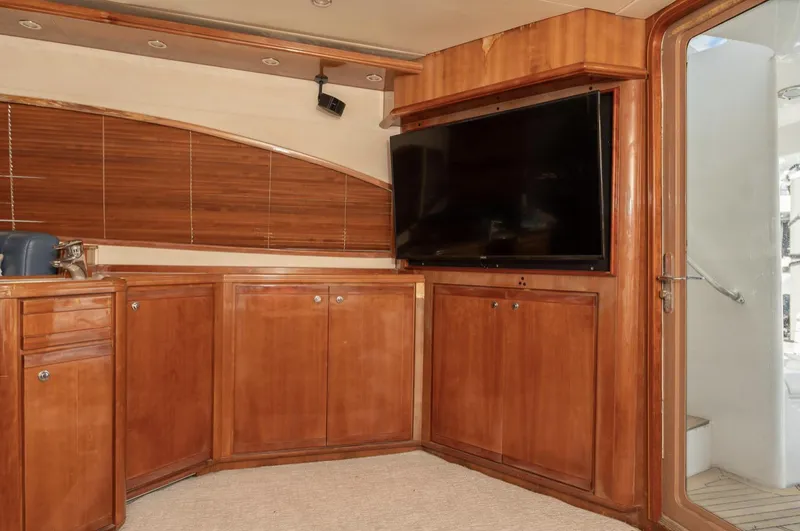  Yacht Photos Pics Luxurious interior of 2004 Bertram 630 yacht with wooden cabinetry and flat-screen TV.
