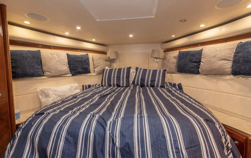  Yacht Photos Pics Luxurious cabin interior of 2004 Bertram 630 yacht with striped bedding.