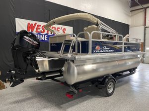2025 Sun Tracker Bass Buggy 16 XL Select pontoon boat with Mercury engine in showroom.