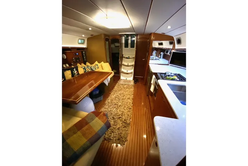 Aundrea Lynn Yacht Photos Pics Interior of 1997 Beneteau Oceanis 461 yacht, featuring cozy seating, dining area, and modern kitchen.