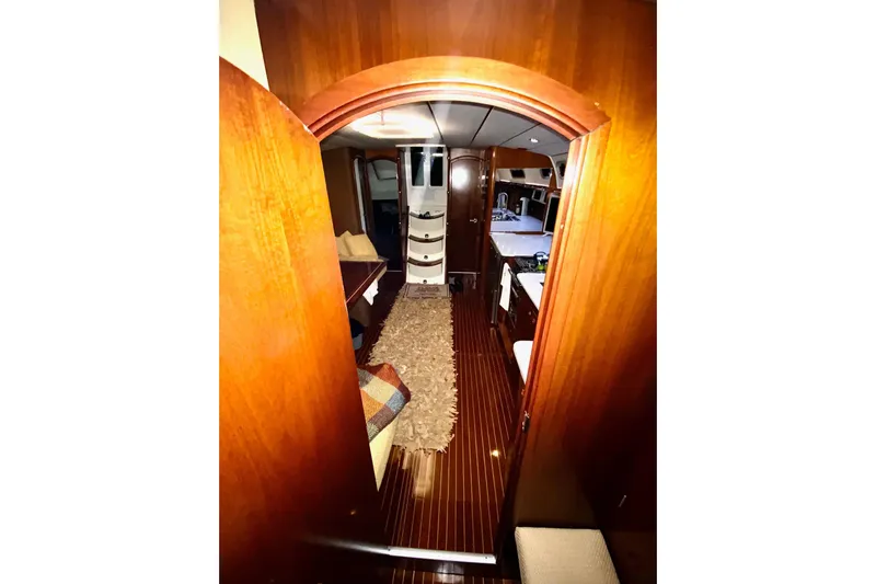 Aundrea Lynn Yacht Photos Pics Interior view of 1997 Beneteau Oceanis 461 yacht, featuring wood paneling and cozy furnishings.