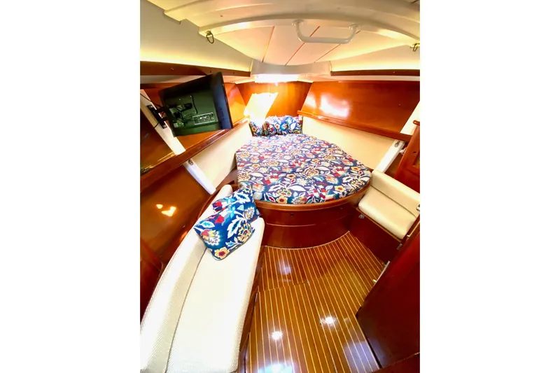Aundrea Lynn Yacht Photos Pics Cozy cabin interior of 1997 Beneteau Oceanis 461 with floral bedding and wood finish.