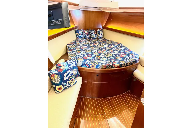 Aundrea Lynn Yacht Photos Pics Cozy cabin interior of 1997 Beneteau Oceanis 461 with floral bedding and wood finish.