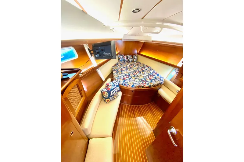 Aundrea Lynn Yacht Photos Pics Cozy cabin interior of 1997 Beneteau Oceanis 461 sailboat with patterned bedding and wooden finish.