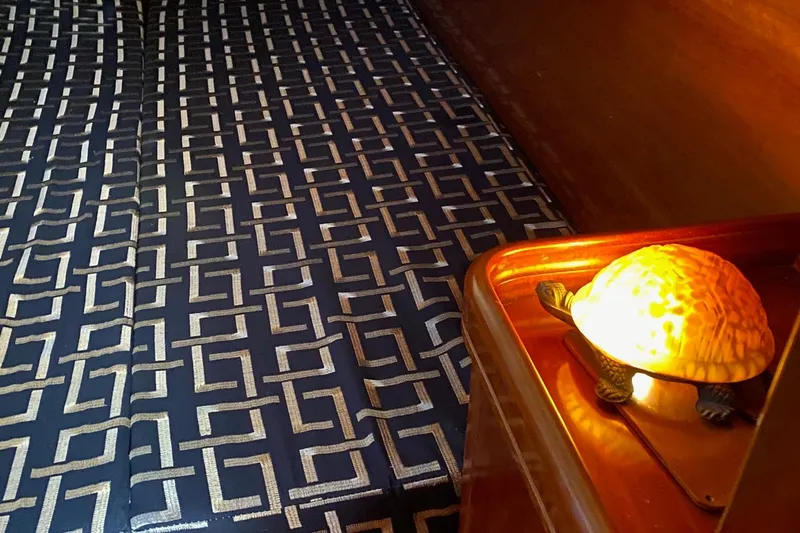 Aundrea Lynn Yacht Photos Pics Cozy cabin interior of 1997 Beneteau Oceanis 461 with patterned bedding and turtle lamp.