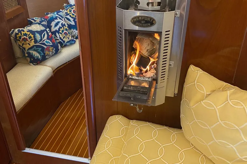 Aundrea Lynn Yacht Photos Pics Cozy interior of 1997 Beneteau Oceanis 461 with a lit fireplace and colorful cushions.