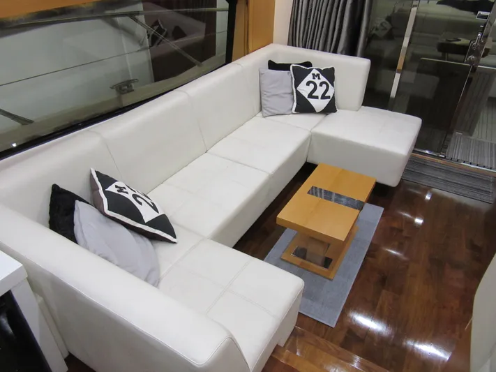 Skeis The Limit Yacht Photos Pics Luxurious interior of 2014 Sunseeker Manhattan 53 yacht with white leather seating and decorative pillows.