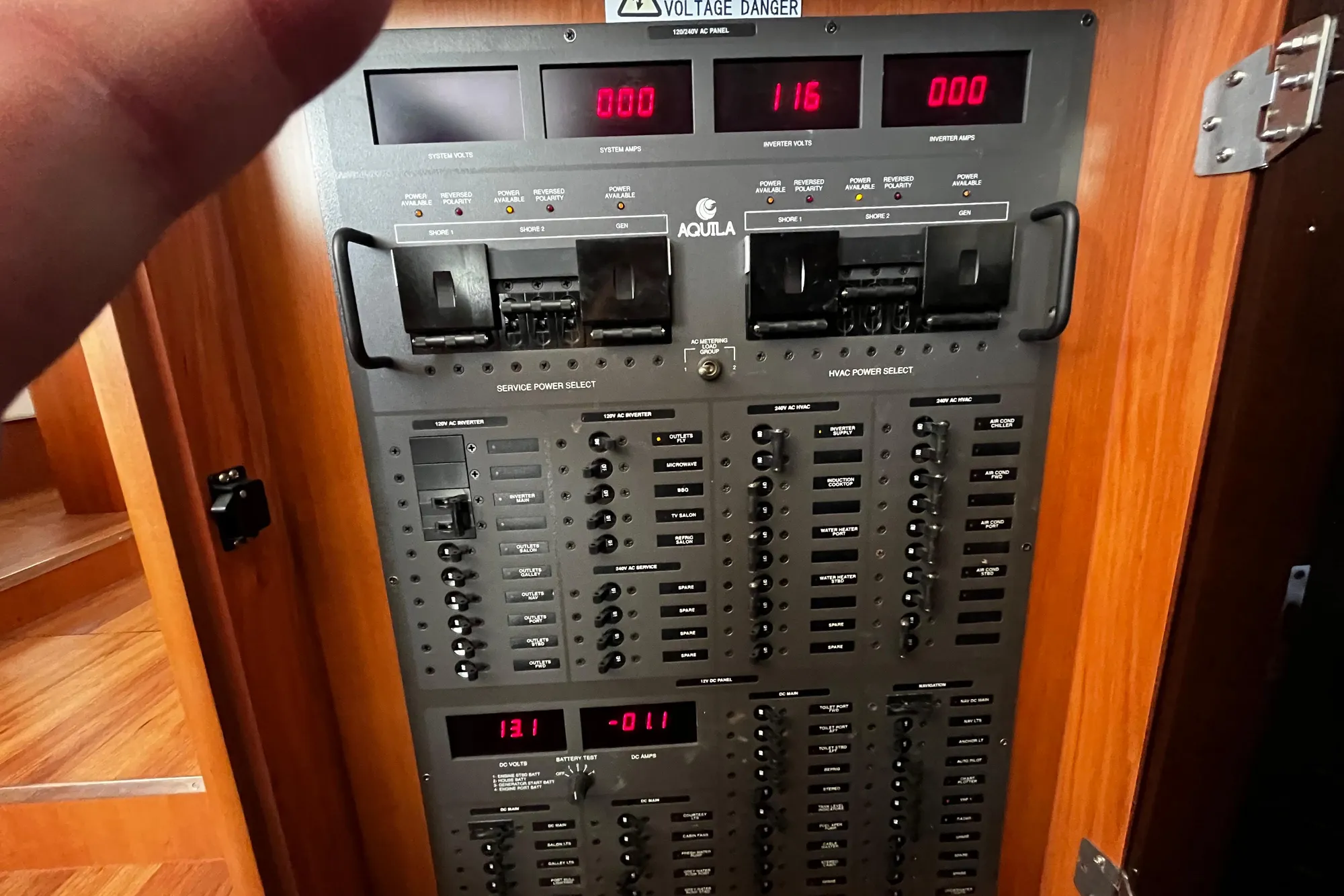Electrical control panel of a 2016 Aquila 44 yacht, displaying voltage and amperage readings.