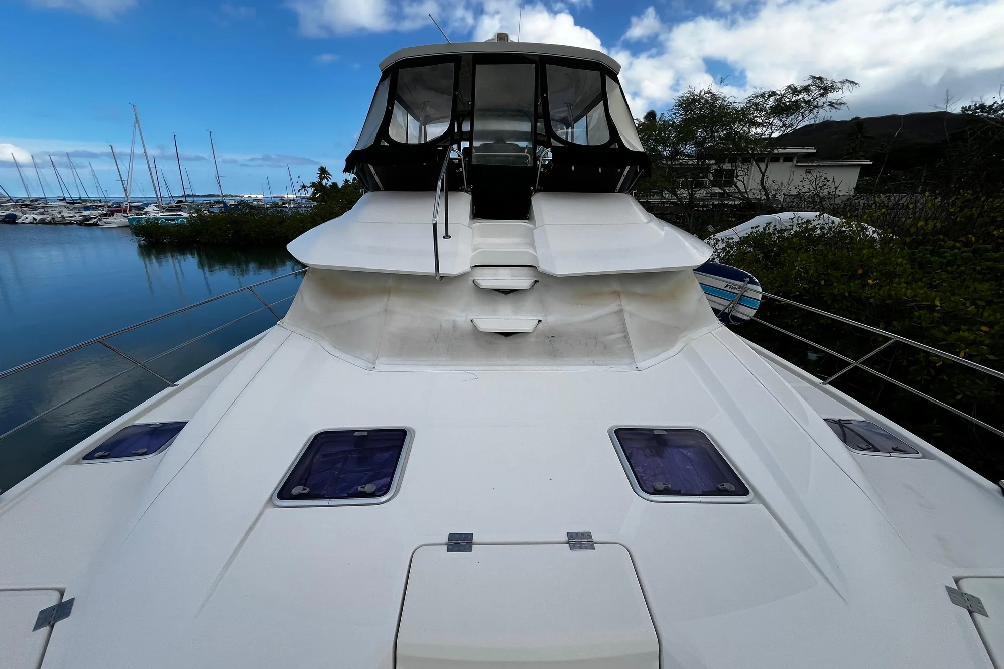 Aquila 44 yacht, 2016 model, docked by a marina under a blue sky.