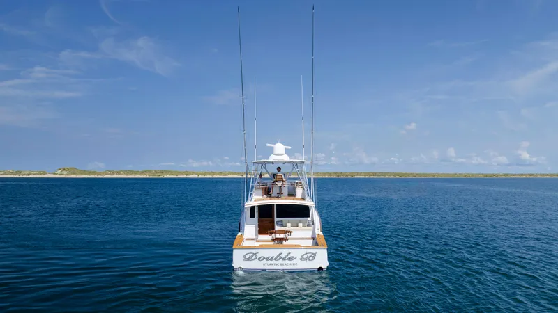 Double B Yacht Photos Pics Custom Carolina Taylor Made 2000 yacht on open sea, clear sky, distant shoreline.