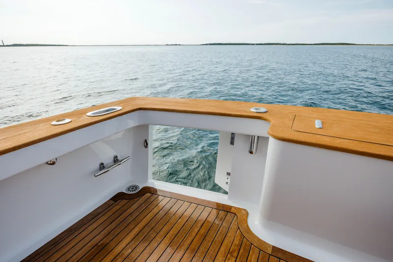 Double B Yacht Photos Pics Custom Carolina Taylor Made 2000 boat deck with wooden finish, overlooking calm ocean waters.