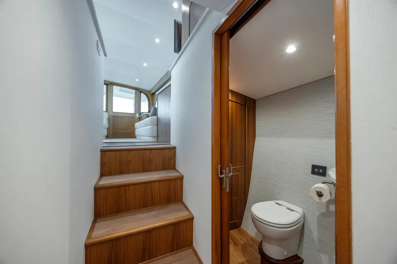 Double B Yacht Photos Pics Interior of 2000 Custom Carolina Taylor Made yacht with wooden stairs and compact bathroom.