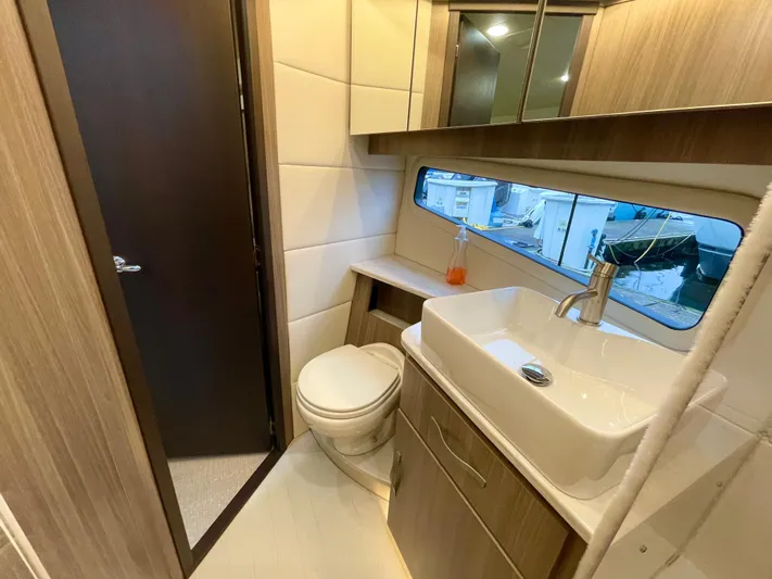 About Time Yacht Photos Pics Luxurious bathroom in 2022 Regal 42 Grande Coupe yacht with modern fixtures and wood accents.