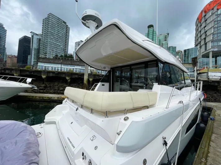 About Time Yacht Photos Pics 2022 Regal 42 Grande Coupe docked in urban marina with city skyline backdrop.