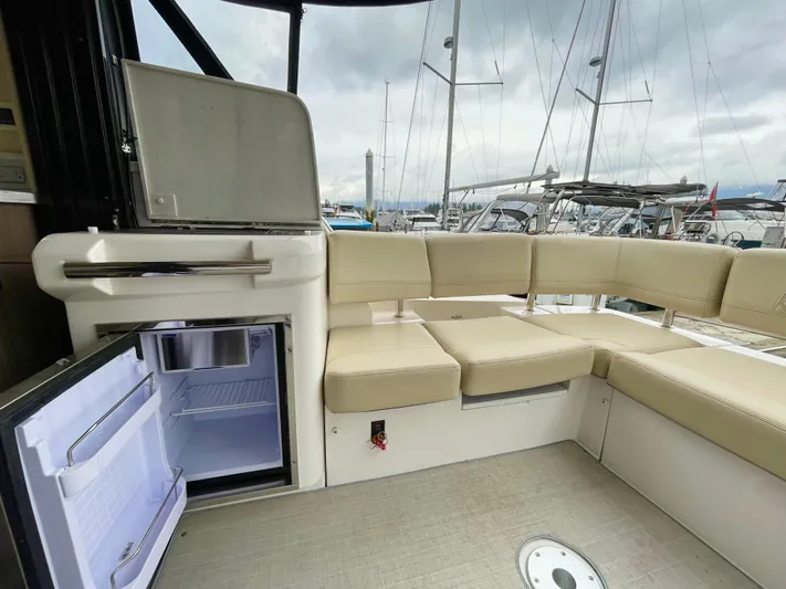 About Time Yacht Photos Pics 2022 Regal 42 Grande Coupe interior with open fridge and beige seating.