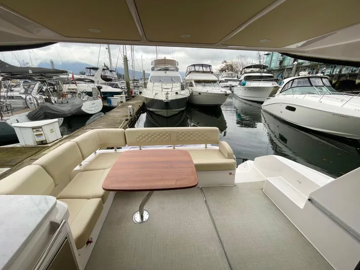 About Time Yacht Photos Pics 2022 Regal 42 Grande Coupe yacht interior with docked boats in marina background.