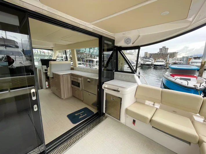 About Time Yacht Photos Pics 2022 Regal 42 Grande Coupe yacht interior with modern kitchen and marina view.