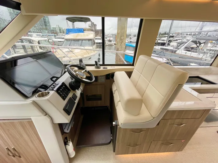 About Time Yacht Photos Pics Interior of 2022 Regal 42 Grande Coupe yacht with helm and seating area.