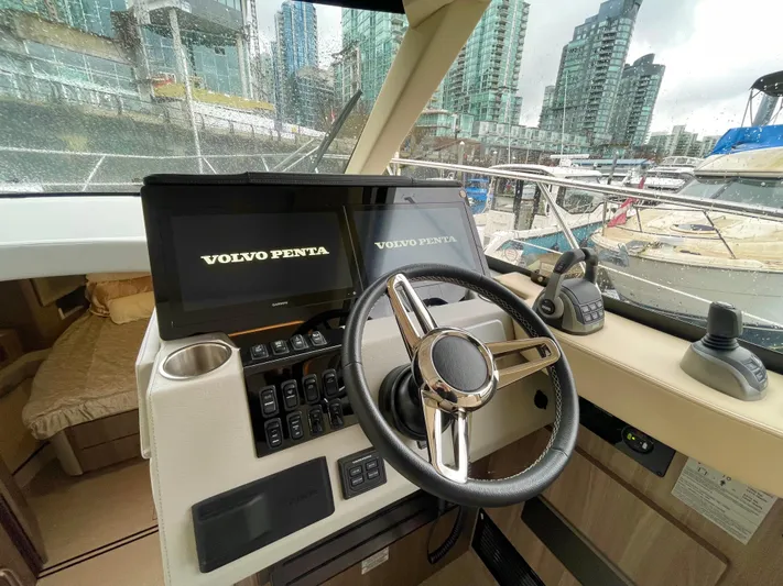 About Time Yacht Photos Pics Interior cockpit of 2022 Regal 42 Grande Coupe with Volvo Penta controls, docked in marina.