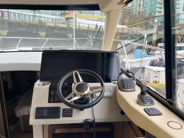 About Time Yacht Photos Pics 2022 Regal 42 Grande Coupe helm with modern controls and waterfront view.