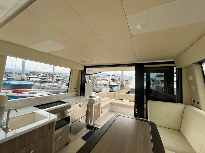 About Time Yacht Photos Pics Luxurious interior of 2022 Regal 42 Grande Coupe yacht with modern kitchen and seating area.