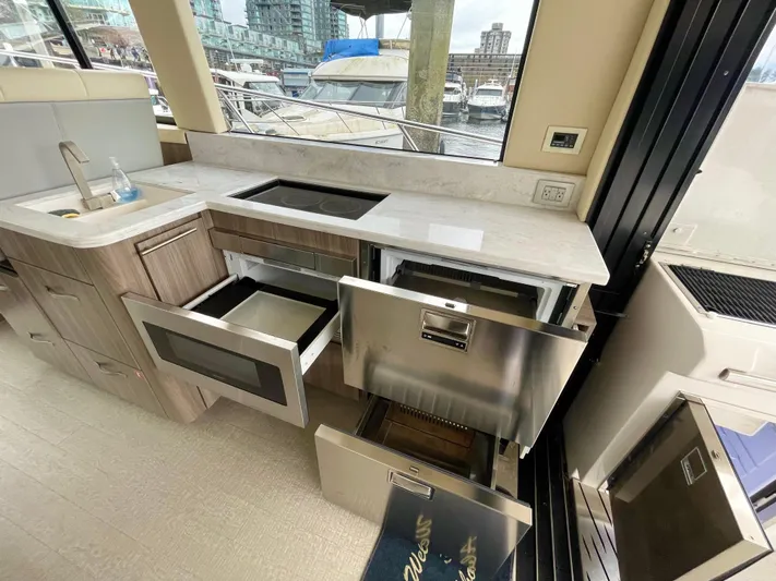 About Time Yacht Photos Pics Modern kitchen in 2022 Regal 42 Grande Coupe yacht with open drawers and appliances.