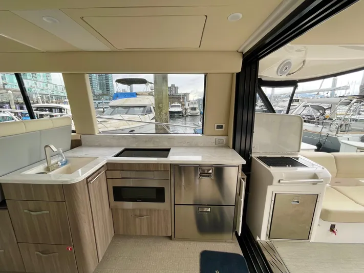 About Time Yacht Photos Pics Modern kitchen interior of 2022 Regal 42 Grande Coupe yacht with marina view.